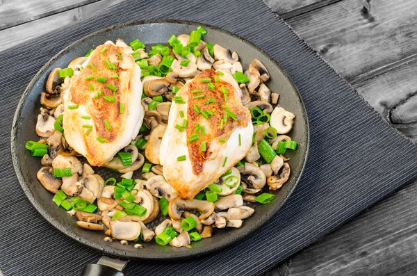 Kippenborst met champignons en de lente-uitjes op pan — Stockfoto