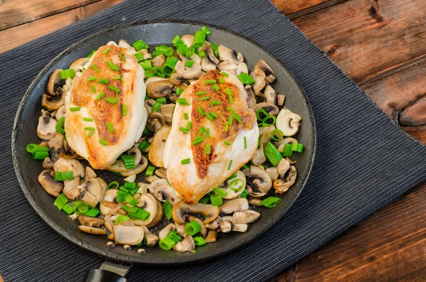 Kippenborst met champignons en de lente-uitjes op pan — Stockfoto