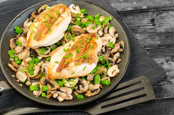 Kippenborst met champignons en de lente-uitjes op pan — Stockfoto