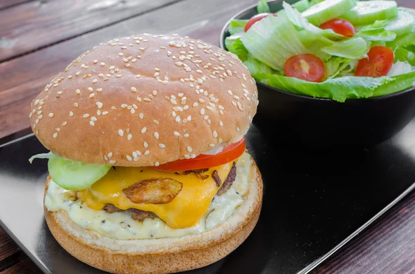 Cheeseburger with bacon and tartar sauce and garden salad — Stock Photo, Image