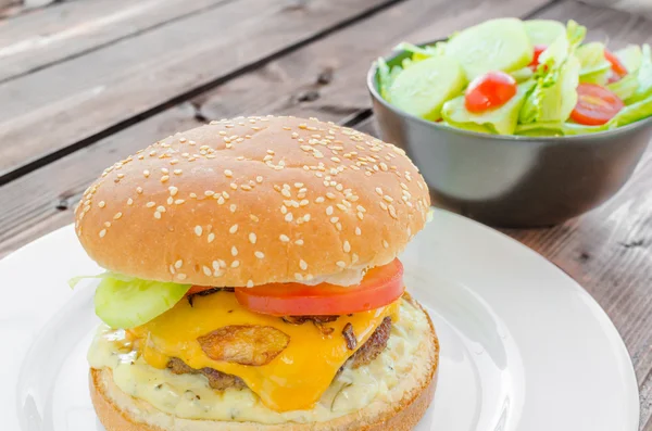 Cheeseburger dengan bacon dan saus tartar dan salad kebun — Stok Foto