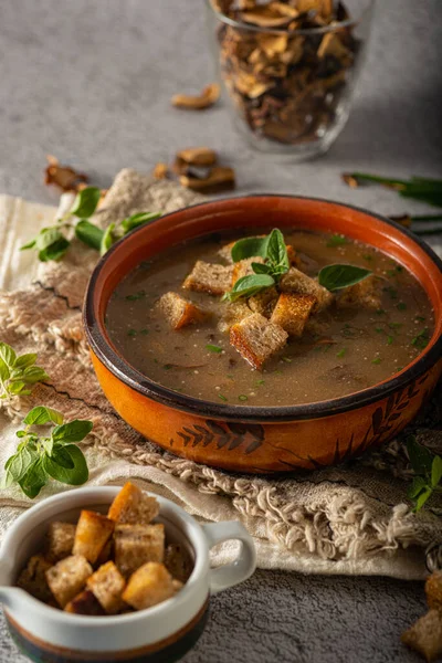 Homemade soup with herbs, crispy pastry and mushrooms