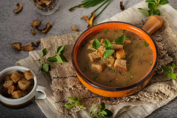 Homemade soup with herbs, crispy pastry and mushrooms