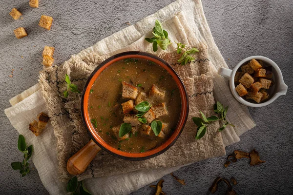 Homemade soup with herbs, crispy pastry and mushrooms