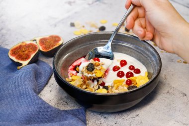 Görünmez bir insanın eli içinde granola olan tabağın yanında. 