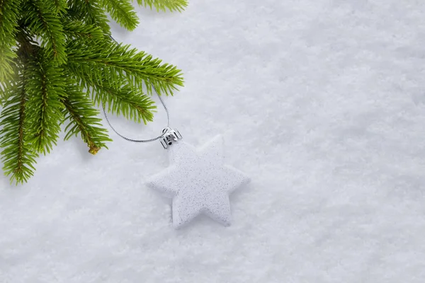 Decoration with the Christmas tree lies on the snow next to the Christmas tree — Stock Photo, Image