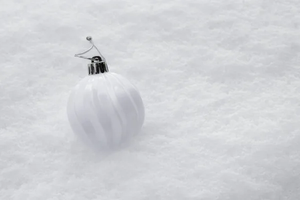 White ball with Christmas tree lies on pure snow — Foto Stock