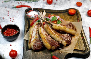 Yan görünüş. Seçici odak noktası kızarmış kuzu kaburgaları tahtada. 