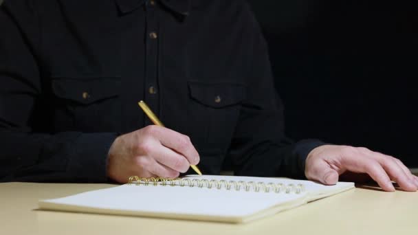 Las manos de un hombre escriben con una pluma dorada sobre papel en blanco — Vídeo de stock