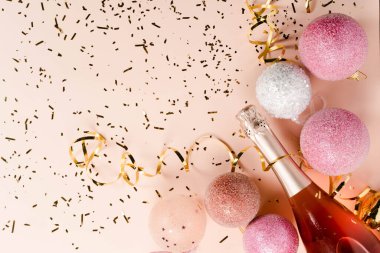 Şampanya şişesi, hediye ya da hediye kutusu ve pembe arka planda altın parıltı.