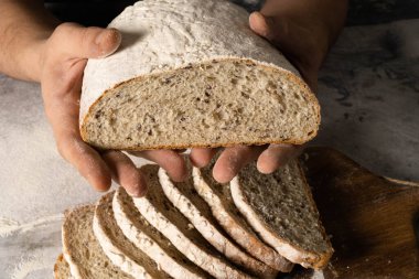 Erkek elleri bir dilim ekmeğe tereyağı sürer..