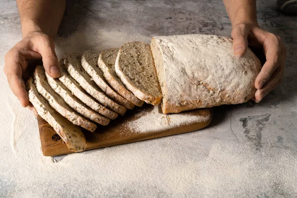 Mãos masculinas espalham manteiga em uma fatia de pão. — Fotografia de Stock