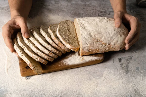 Mannelijke handen smeren boter op een sneetje brood. — Stockfoto