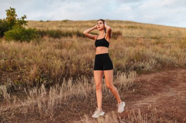 Şehir parkında koşmak. Kadın koşucu arka planda Sunset silueti ile dışarıda koşuyor