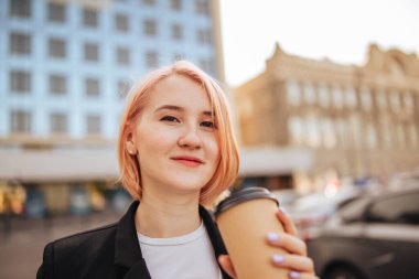 Cep telefonu cihazlı genç bir iş kadını ve açık havada kahve yapan bir eko kağıt.