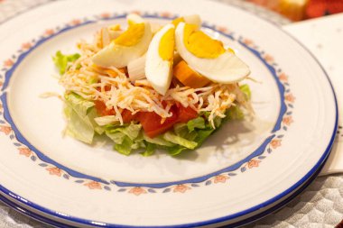 Sağlıklı salata, altta salata, domates, deniz ürünü ve seçici odaklı bir restoranda tatil için kaynamış yumurta..