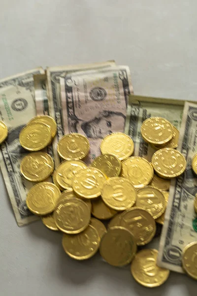 Monedas de chocolate de oro colocadas en el dinero del dólar real con el concepto de enfoque selectivo comprar venta — Foto de Stock