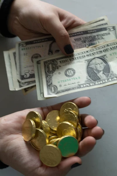 Monedas de chocolate dorado colocadas en una mano y dinero en dólares colocados en la otra concepto de valor y economía — Foto de Stock