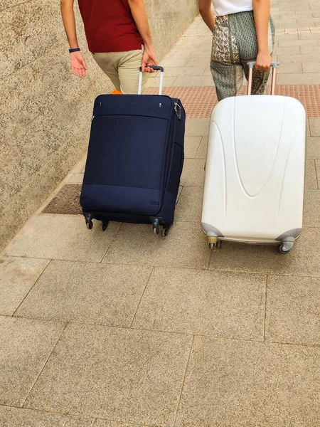 自転車のスーツケースを持った2人の若者が選択的焦点で休暇旅行に行くために歩く — ストック写真