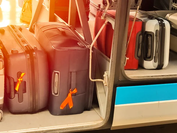 set of colored suitcases placed in the luggage compartment for selective focus traveling