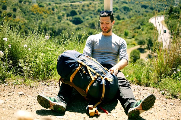 Viajero joven descansando sentado en la colina — Foto de Stock