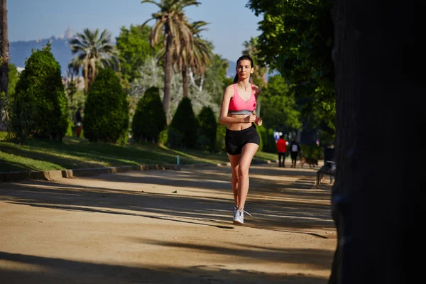 Beautiful athletic girl running in the green park — Stock Photo, Image