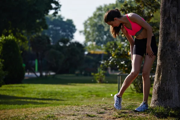 Sportos lány állt a fű, és pihenés után a kocogás — Stock Fotó