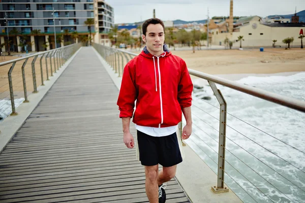 Atletische runner wandelen op de pier en op zoek weg — Stockfoto