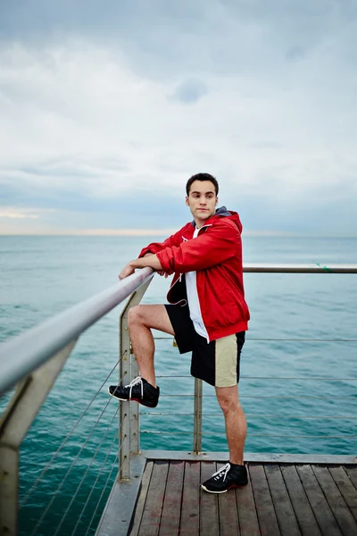 Man permanent op de pier van de zee en op zoek weg — Stockfoto