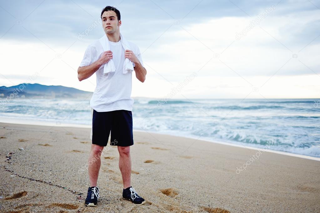 Attractive young jogger taking a break after run