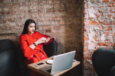 Yukarıdan gelen rüya gibi bayan müdürün elinde bir kupa sıcak çayla elinde dizüstü bilgisayarı ve akıllı telefonu var.