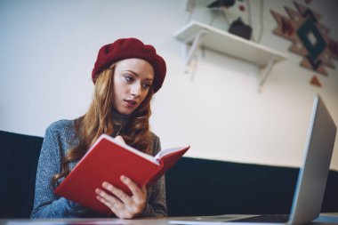 Modern çalışma ortamında iş yaparken bilgisayarında bilgisayarını açıp bilgiyi yeniden yazan çekici bir kadının düşük açılı açısı.