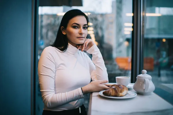 Mujer Pensativa Mirando Cámara Mientras Está Sentado Mesa Cafetería Ligera —  Fotos de Stock