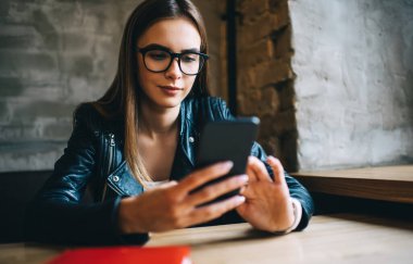 Kafkasyalı blogcu, akıllı telefon ağı kurulumu sırasında optik gözlüklü yeniyetme kız mesajlar gönderiyor ve cep telefonunda kurulum için uygulama arıyor.