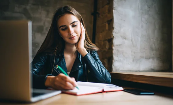 Inteligentna Studentka Skórzanej Kurtce Siedząca Przy Stole Laptopem Badań Online — Zdjęcie stockowe