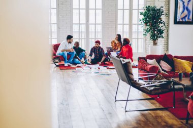 Kağıt raporları olan yeniyetme gençler birlikte başlatılan iş planı hakkında iletişim kuruyor, çok kültürlü erkek ve kadın öğrenciler apartmanda eğitim kurslarını tartışıyorlar.