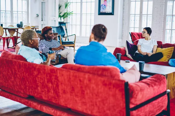 Oturma odasındaki konuklarla iletişim kuran genç ve çeşitli arkadaşlar. Boş zamanlarında apartman dairesinde dostça sohbet eden bir grup hippi.