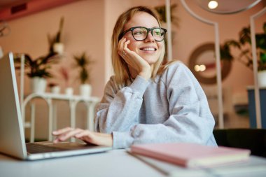 Modern dizüstü bilgisayarı olan kaygısız yeniyetme kız internete bakıyor ve haftasonu serbest çalışanlar için internette popüler olmanın hayalini kuruyor. Modern netbook 'lu mutlu blog yazarı.