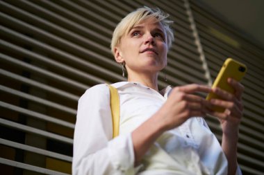 Modern cep telefonu cihazıyla tefekkür eden kadın blogcu 4G kablosuz internet kullanarak metin yayınlama fikri üzerinde kafa yoruyor. Mobil teknolojili düşünceli hippi kız.