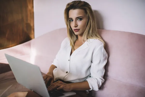 Mujer Joven Contenta Escribiendo Netbook Trabajando Sola Mientras Mira Cámara — Foto de Stock