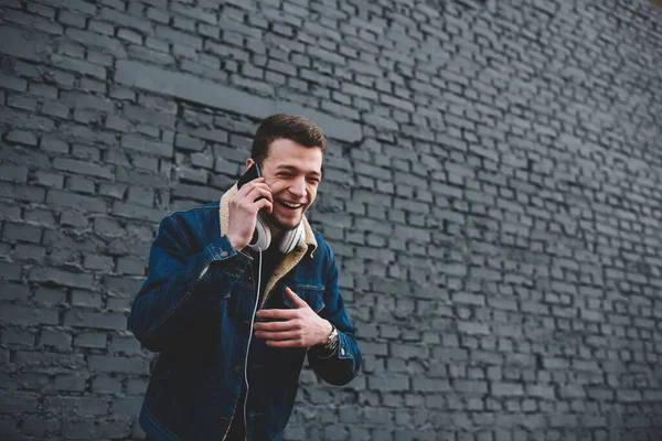Joyful Guy Jean Jacket Headphones Neck Laughing While Having Smartphone — Stock Photo, Image