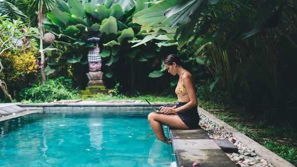 Vista Lateral Mujer Enfocada Ropa Verano Sentada Piscina Con Piernas —  Fotos de Stock