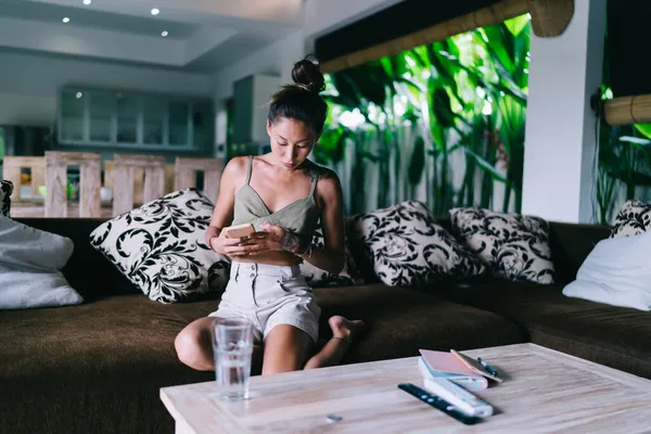 Modern Bali Otel Odasındaki Kanepede Dinlenirken Akıllı Telefon Kullanan Yaz — Stok fotoğraf