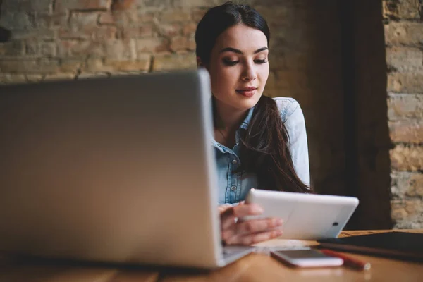 Fiatal Koncentrált Női Szabadúszó Asztalnál Modern Laptop Videó Nézése Tabletta — Stock Fotó