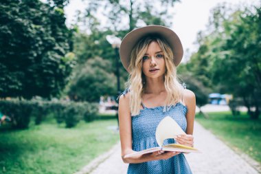 Kişisel günlüğü olan beyaz bir öğrenci parkta boş zamanlarında kameraya bakıyor, moda şapka takan kadın blogcu dışarıda eğitim defteri ya da edebiyat kitabı tutuyor.