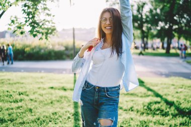 Göz giysisi ve elektronik kulaklıklı neşeli kadın blog yazarının yarım boy portresi, boş zamanların tadını çıkaran mutlu Kafkasyalı blogcu cep telefonu cihazıyla kameraya gülümseyen ve medya kayıtlarını dinleyen