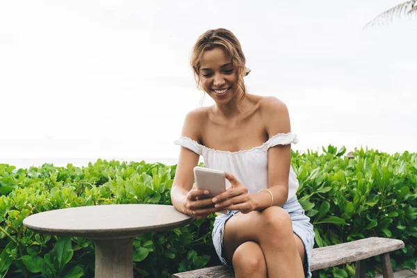 Mulher Feliz Roupa Verão Que Navega Smartphone Enquanto Sentado Banco — Fotografia de Stock