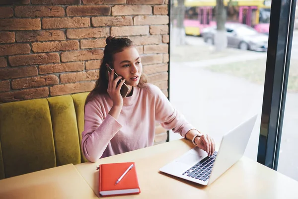 Fentről Figyelmes Női Szabadúszó Néz Félre Asztalnál Modern Laptop Telefonhívás — Stock Fotó