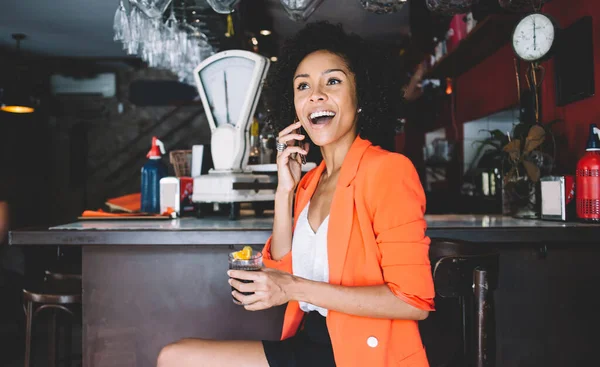 Joven Dama Negra Con Chaqueta Brillante Sosteniendo Refrescante Cóctel Sentado —  Fotos de Stock