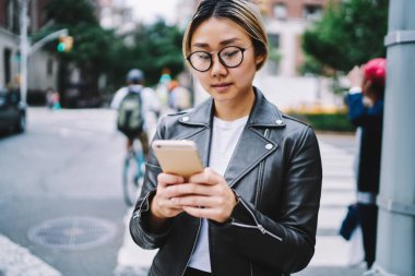 Modern cep telefonu cihazında 4G kablosuz internet kullanan modacı kız sosyal ağlarda web mesajlaşması için Asyalı blogcu, medya sayfasına paylaşmak için içerik yayını yaratıyor